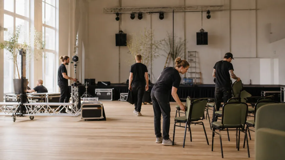Event crew setting up chairs and stage equipment